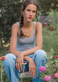 Woman sitting in a garden with flowers and greenery